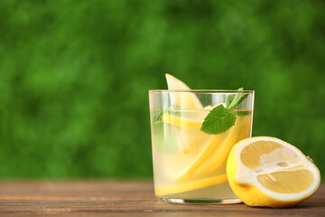 Glass with fresh lemonade on wooden table