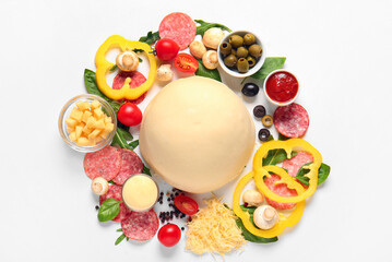 Raw dough and ingredients for preparing pizza on white background