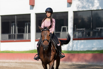 Young mexican woman riding a horse in her ranch