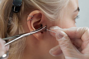 Professional holding the jewel of piercing day just before screw the ball. Tragus type.