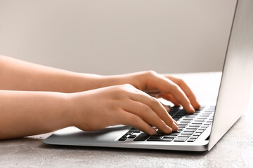 Female programmer using laptop on light table, closeup