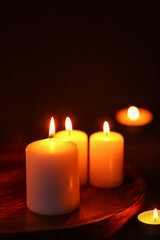 Fototapeta na wymiar Beautiful burning candles on black background