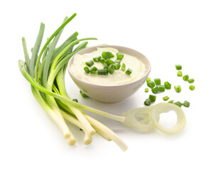 Bowl of tasty sour cream with sliced scallion and onion on white background