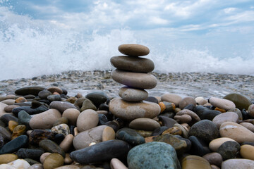 Fototapeta na wymiar Beautifully laid stones against the background of the sea surf