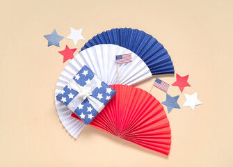 Gift box with colorful fans, USA flags and stars on pale yellow background. American Independence Day