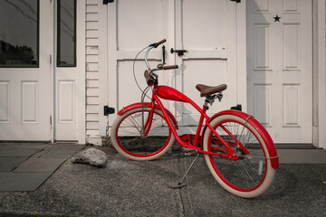 Red rustic bike parked in front of the white wall