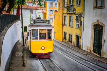 Famous vintage yellow tram 28 in the narrow streets of Alfama district in Lisbon, Portugal - symbol of Lisbon, famous popular travel destination and tourist attraction