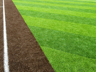 Synthetic turf baseball field with alternating green panels along third base line.	