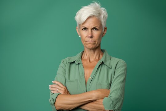 Medium shot portrait photography of a satisfied mature woman showing a thumb down against a sea-green background. With generative AI technology