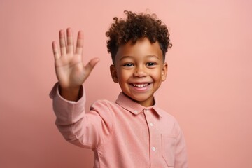 Medium shot portrait photography of a happy boy in his 30s waving with the hand against a peachy pink background. With generative AI technology