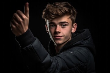 Medium shot portrait photography of a satisfied boy in his 20s raising a finger as if having an idea against a matte black background. With generative AI technology