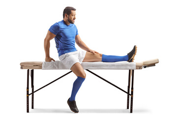 Football player sitting on a massage bed