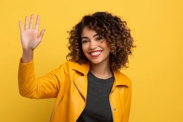 Medium shot portrait photography of a glad girl in her 30s waving with the hand against a bright yellow background. With generative AI technology