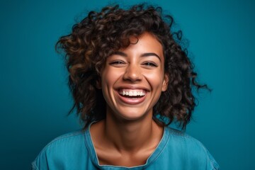 Medium shot portrait photography of a grinning girl in her 30s giving a hug to the camera against a teal blue background. With generative AI technology