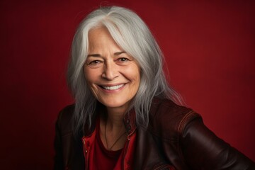 Headshot portrait photography of a glad mature woman giving a hug to the camera against a cherry red background. With generative AI technology