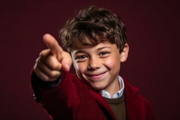 Close-up portrait photography of a grinning boy in his 30s raising a finger as if having an idea against a burgundy red background. With generative AI technology