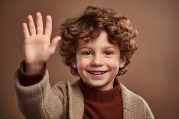 Close-up portrait photography of a joyful boy in his 30s waving with the hand against a warm taupe background. With generative AI technology