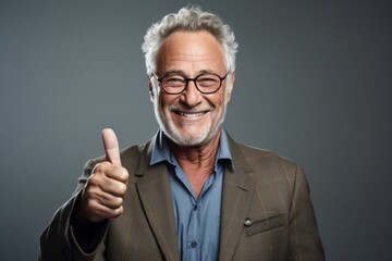 Medium shot portrait photography of a grinning mature man making an ok gesture with the fingers against a cool gray background. With generative AI technology