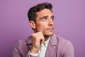 Headshot portrait photography of a glad boy in his 30s putting the hand on the chin as if thinking against a lilac purple background. With generative AI technology