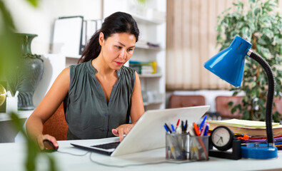 Office manager works with documents and laptop in office