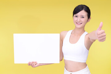 ホワイトボードを持つタンクトップ姿の女性