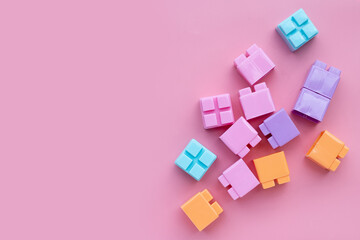 Fototapeta na wymiar Plastic building blocks on pink background. Top view