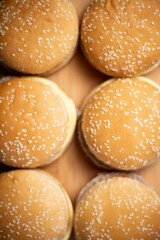 Close-up of cheeseburgers or hamburgers on a wooden background. Food background. Buns with sesame.
