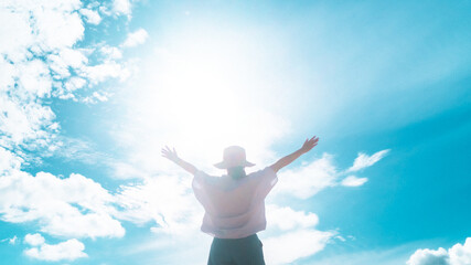 Woman rise hand up to amazing blue sky feel never give up and freedom.