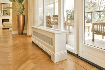 a living room with wood flooring and white trim around the window simh is in front of the door