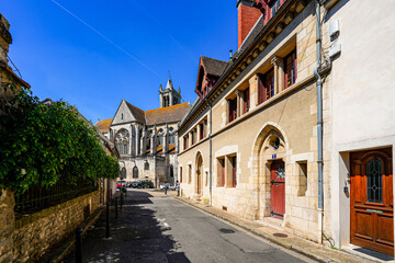 Fototapeta na wymiar Old street leading to Our Lady of the Nativity Church in the former medieval walled city of Moret-sur-Loing in Seine et Marne, France