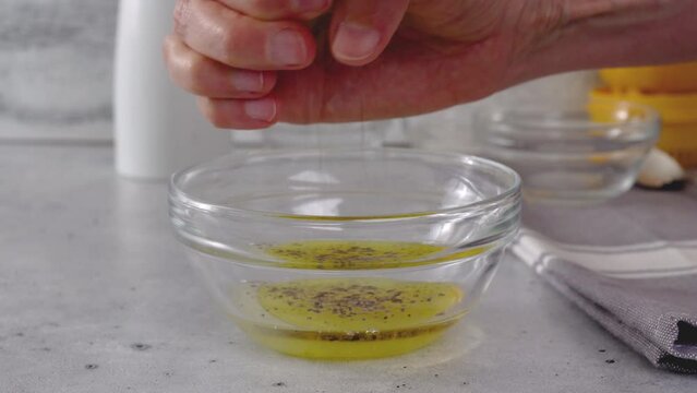 Squizing fresh lemon. Lemon-olive oil salad dressing recipe, ingredients close-up