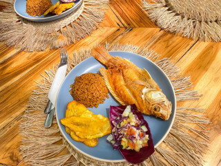 Fried fish with coconut rice and patacones.