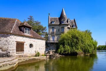 Fototapeta na wymiar Stately home with a round tower built on a wall over the river Loing in the medieval town of Moret-sur-Loing in Seine et Marne, France