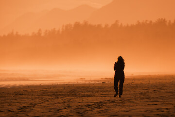 A woman walks alone at Long Beach in the Pacific Rim National Park Reserve on the west coast of  Vancouver Island