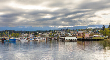 Fototapeta na wymiar The harbour of Port Alberni, B.C., is seen from a boat on the Alberni Inlet. The waterfront features shops, galleries and eateries.