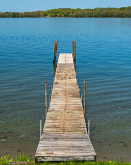 Obraz premium A wooden pier into Lake Chautauqua in Beemus Point, New York, USA on a sunny spring day