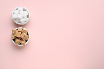 White and brown sugar cubes on pink background, flat lay. Space for text