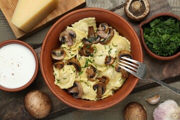 Delicious ravioli with mushrooms and ingredients on wooden table, flat lay