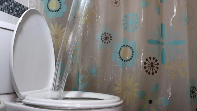 Manual flushing of the toilet from the container, slow motion