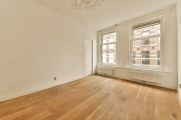 an empty room with wood flooring and white paint on the walls, there is a chandel in the corner