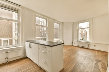 an empty kitchen with wood flooring and white cabinets in the room is very spacious, but it's not too