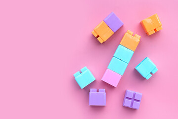 Plastic building blocks isolated on pink background. Top view