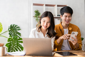 Business couple and successful business asian woman work together in the morning with laptop and paperwork discussing home finances.