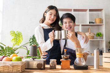 Asian man and woman preparing food and bread to make a healthy breakfast. Enjoying cooking with joy, a charming wife and cheerful husband are preparing delightful meals with fresh ingredients.