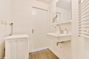 Naklejka na ściany i meble a bathroom with white walls and wood flooring in the shower area, including a sink and mirror on the wall