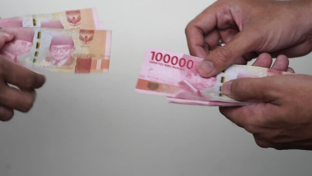 Someone manually counted one hundred thousand rupiah