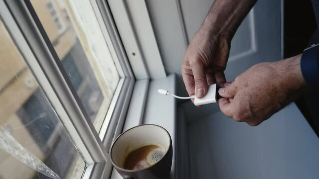 Man plugs in SD card reader adapter into a mobile phone
