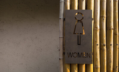 Ladies toilet sign bamboo background
