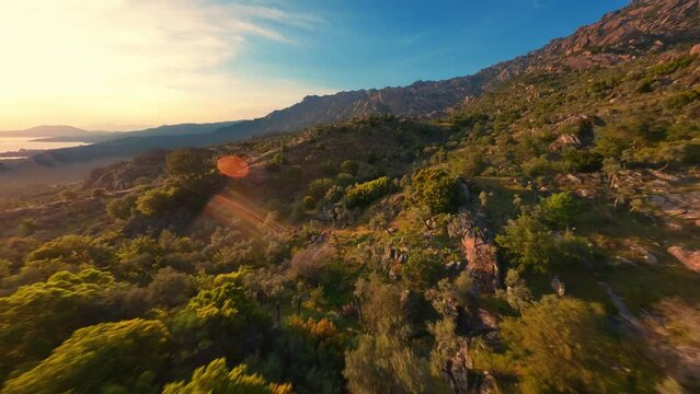 FPV drone flying over beautiful mountains at sunset. 
Lake Bafa surroundings. Turkey.
Smooth flight close to branches