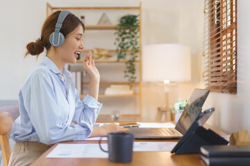 Remote business concept, Businesswoman wear headphone to meeting and greeting partner in video call
